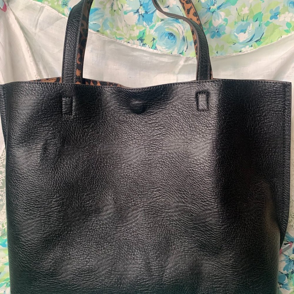 Simple black faux leather bag with a cheetah lining and attached zipper pouch